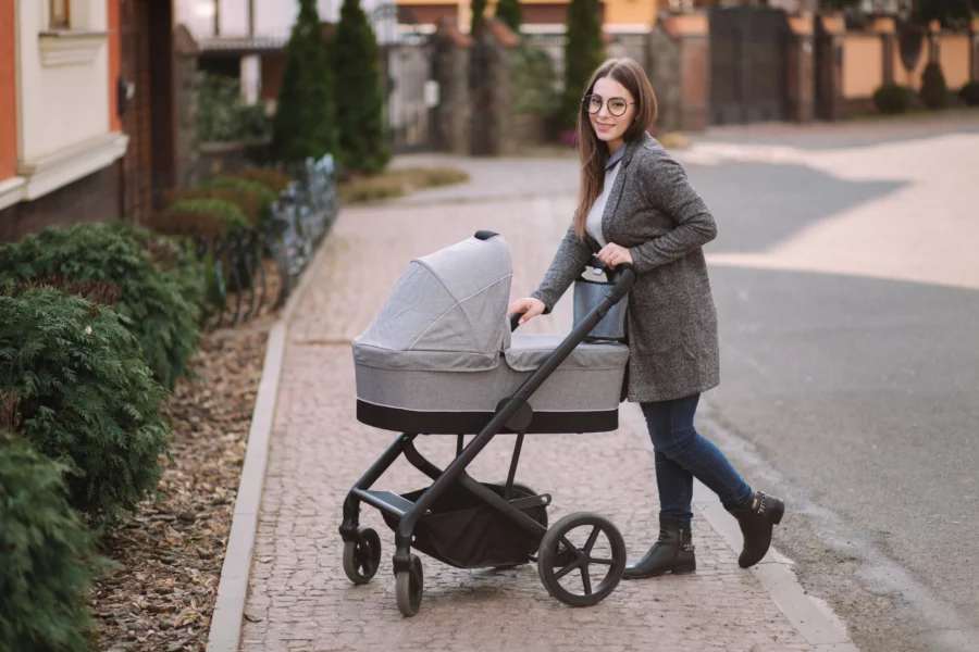 Junge Frau mit Kinderwagen